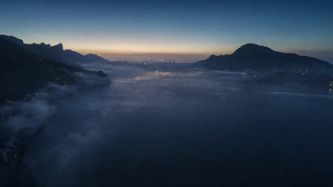 Amanhecer sobre a Lagoa Rodrigo de Freitas, o Cristo Redentor em silhueta.